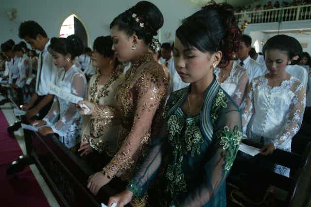 Young Christians wearing traditional dress at a church service.