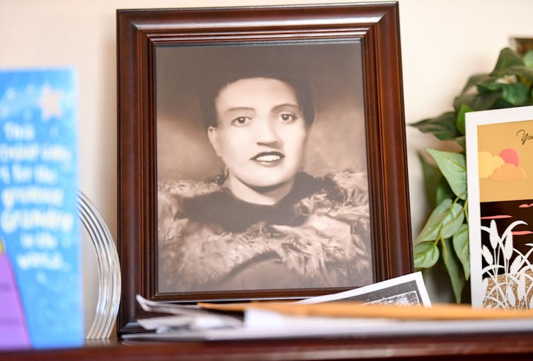 Sepia toned portrait photograph of young woman on a mantle.