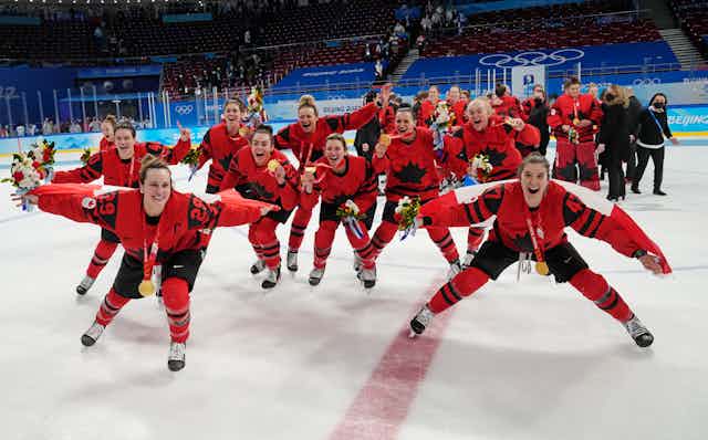 Women in team Canada uniforms skate towards the camera