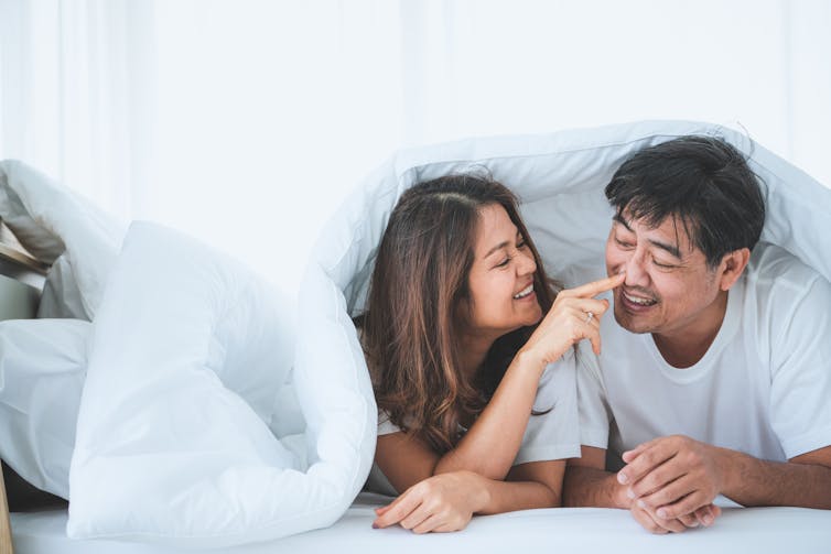 couple look affectionate in bed