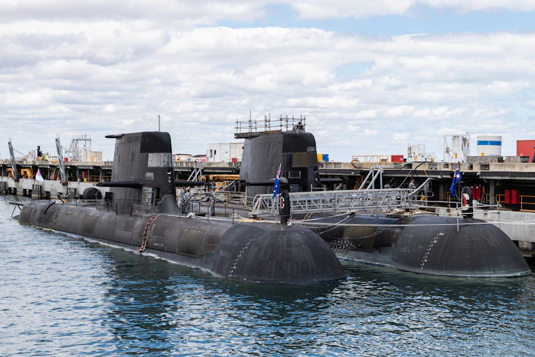 Two Collins class submarines parked in the water