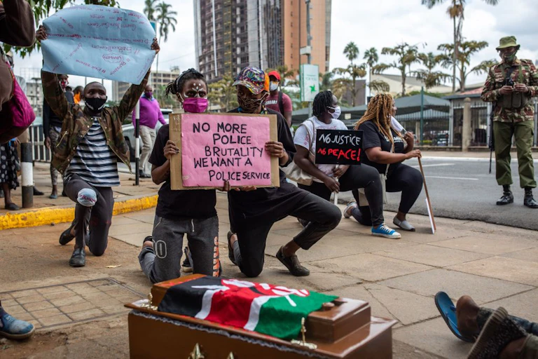 People on their knees holding placards