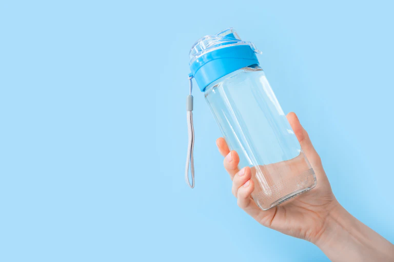 A hand holding a water bottle.