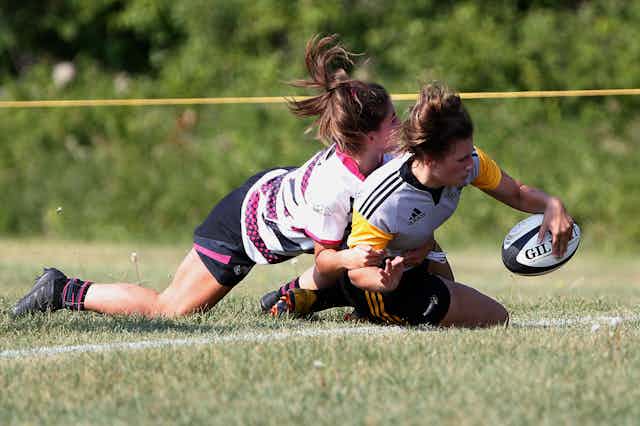 two girls in a tackle while playing rugby