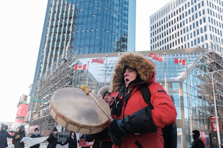 A person drums and sings with supporters in Winnipeg to protest against the construction of a pipeline on Wet'suwet'en territory.