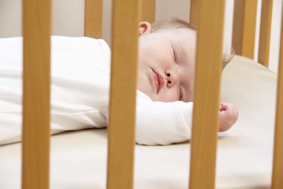 Baby sleeps in a cot