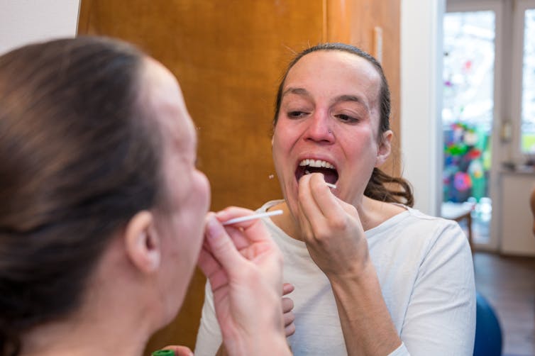 Woman swabs her throat.