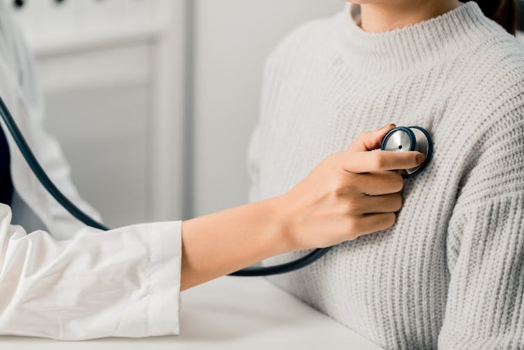 doctor checks patient's heartbeat