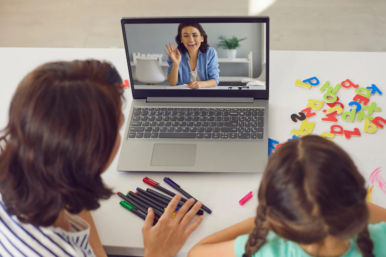 Parent and child talking to teacher online