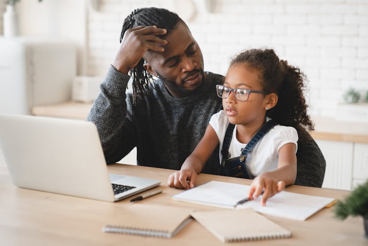 Father and daughter doing online learning