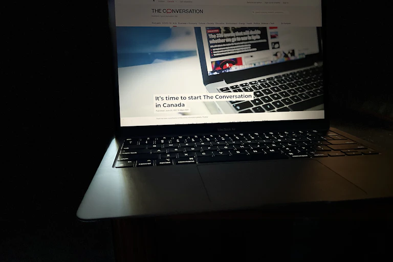 A laptop displays the first article printed by The Conversation in 2017, with the headline It's time to start The Conversation in Canada