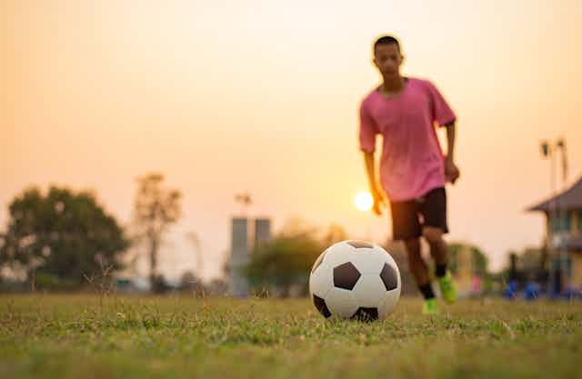A youth runs towards a football.