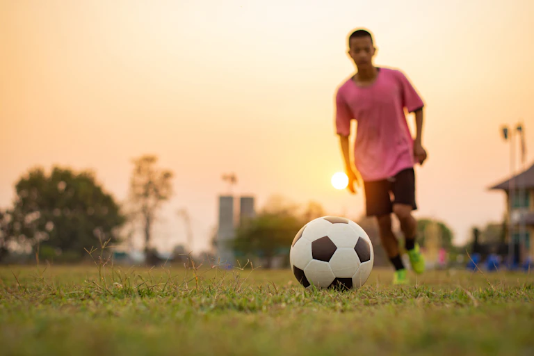 A youth runs towards a football.