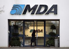 A Building With The Logo 'Mda' Written In Front Of It