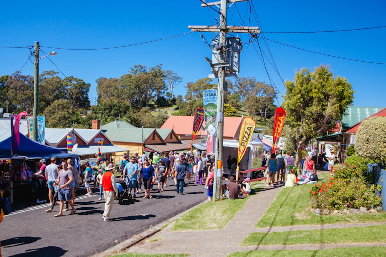 people walk down colourful street