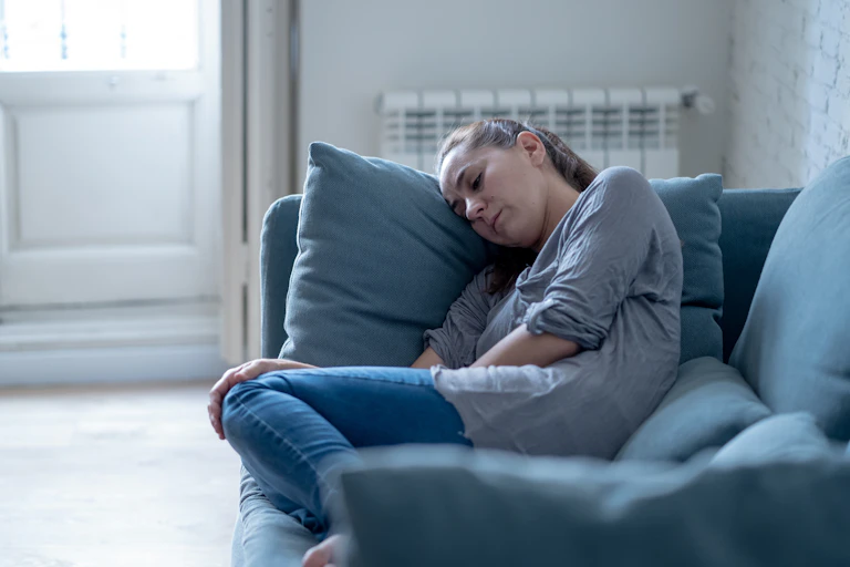 Woman sleeps on a couch.