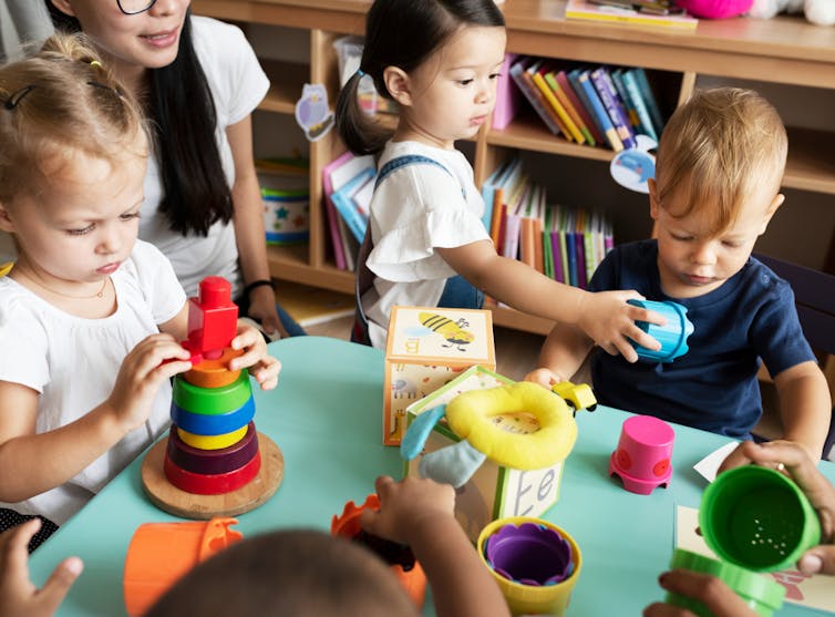 Preschoolers playing at daycare with blocks at table