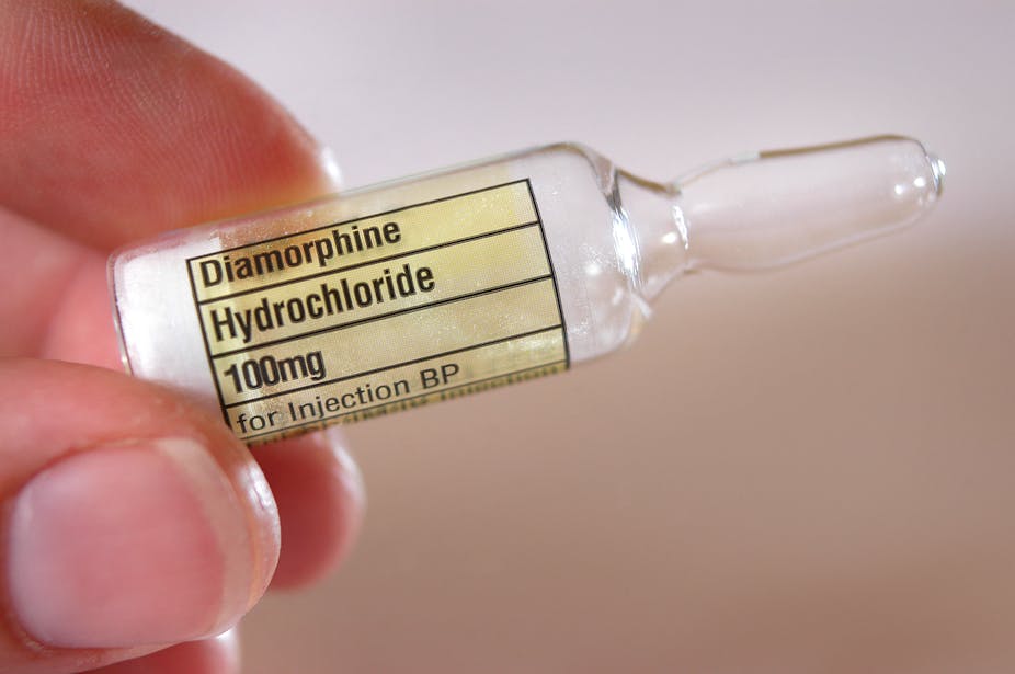 A person holding a vial of diamorphine between their fingers.