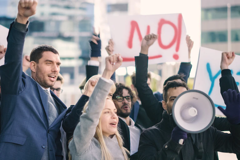 Men and women outside, protesting, picketing, with signs and a megaphone