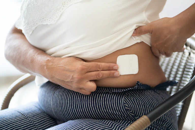 Woman with HRT patch on abdomen