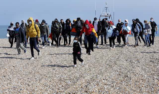 A group of Channel-crossing migrants who have arrived on a Kent beach.