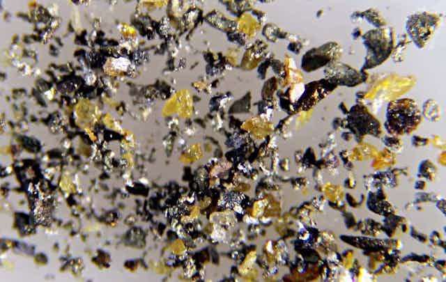 Photo de microgranules de cadmium sous forme native associés à des fragments de sphalérite jaunes.