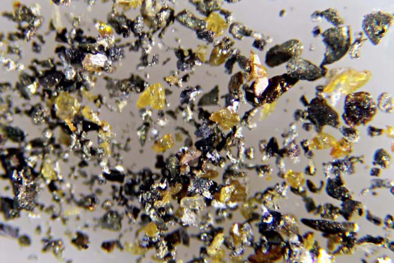 Photo de microgranules de cadmium sous forme native associés à des fragments de sphalérite jaunes.