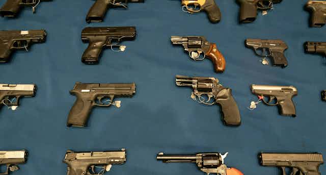 A variety of handguns are seen on a table.