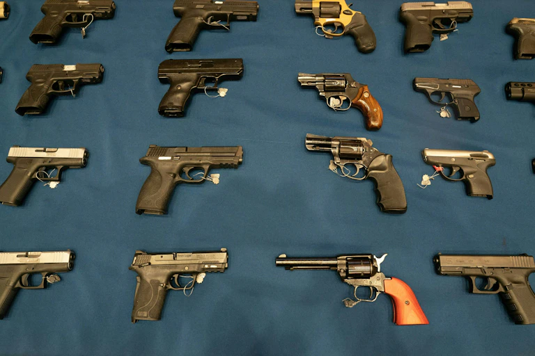 A variety of handguns are seen on a table.