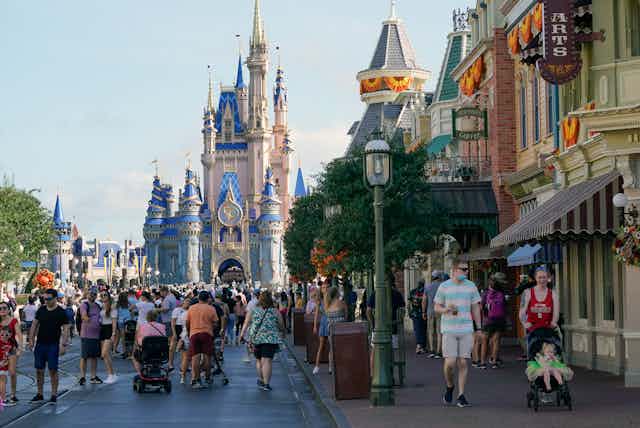 The Magic Kingdom at Disney is pictured with visitors in the forground