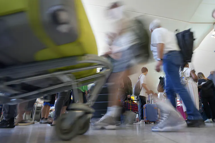 A blurred photo of people walking back and forth in an airport
