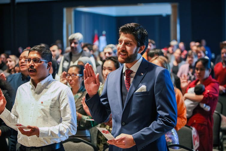 A congregation of people reciting an oath and holding their right hands up