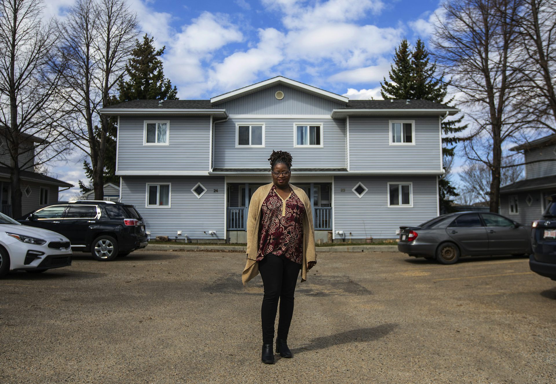 A woman standing in front of a house