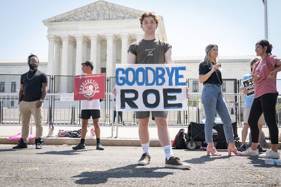 A man holds a sign outside the US Supreme Court, which reads "Goodbye Roe".