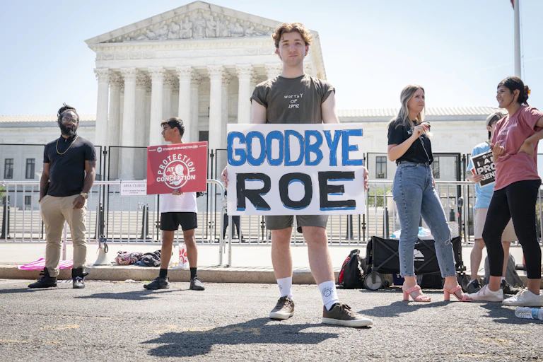 A man holds a sign outside the US Supreme Court, which reads "Goodbye Roe".