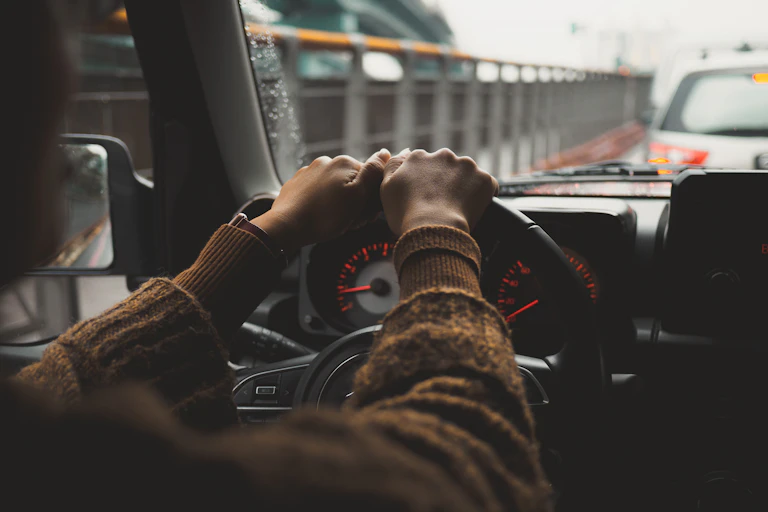 Mains d'une personne au volant dans un embouteillage