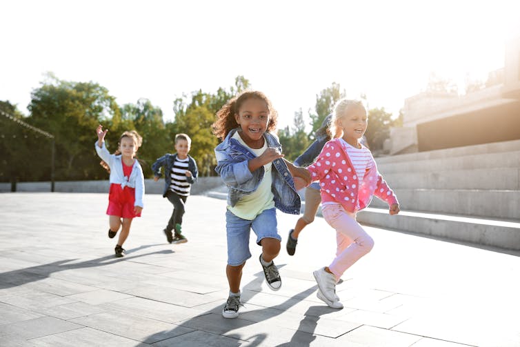 A group of children are seen running outside.