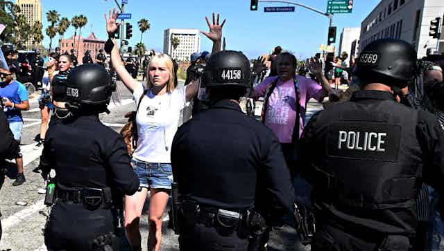 Woman holding her hands up to police at protest