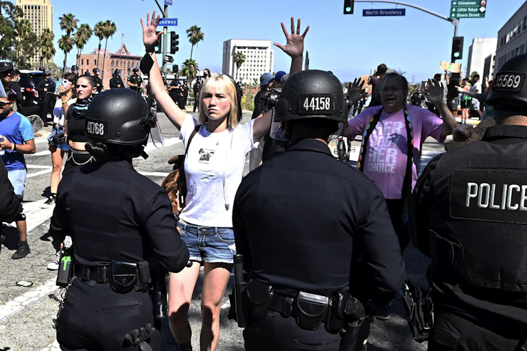 Woman holding her hands up to police at protest