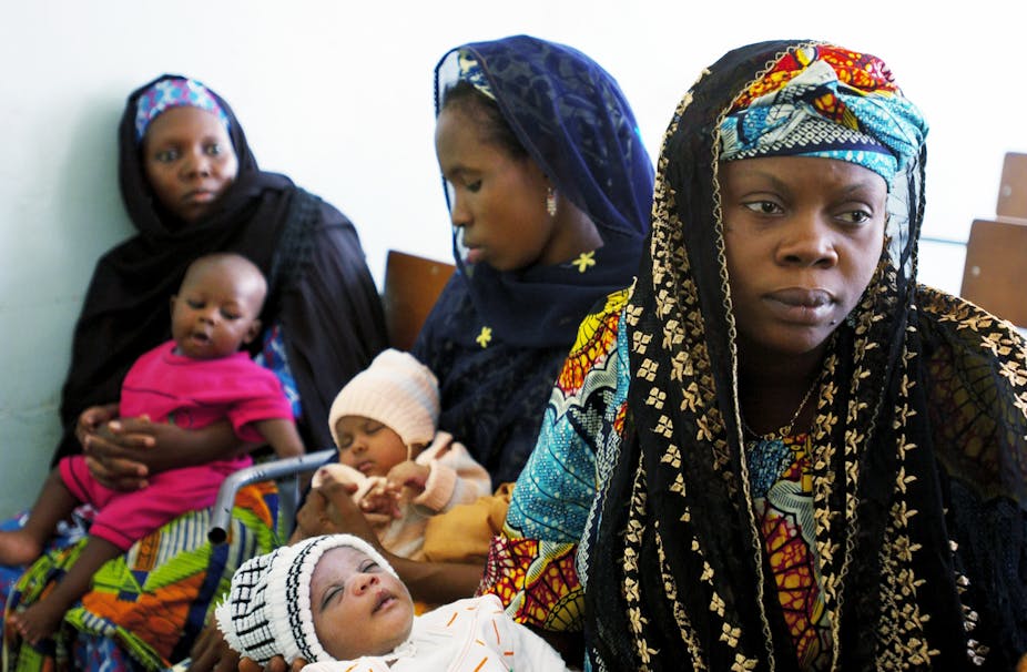 Mothers wait to have their children immunized against a series of diseases in Kano, Nigeria