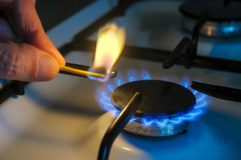 Lighting stovetop gas burner with match