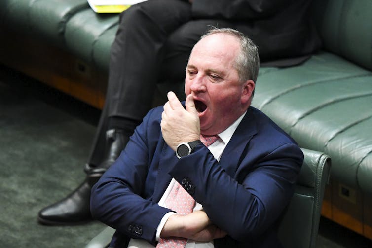 man in suit yawns