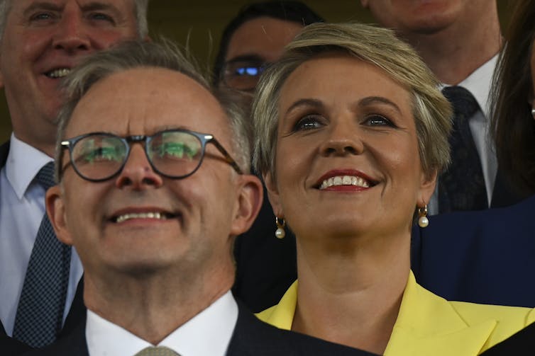 man in glasses and woman in yellow jacket smile