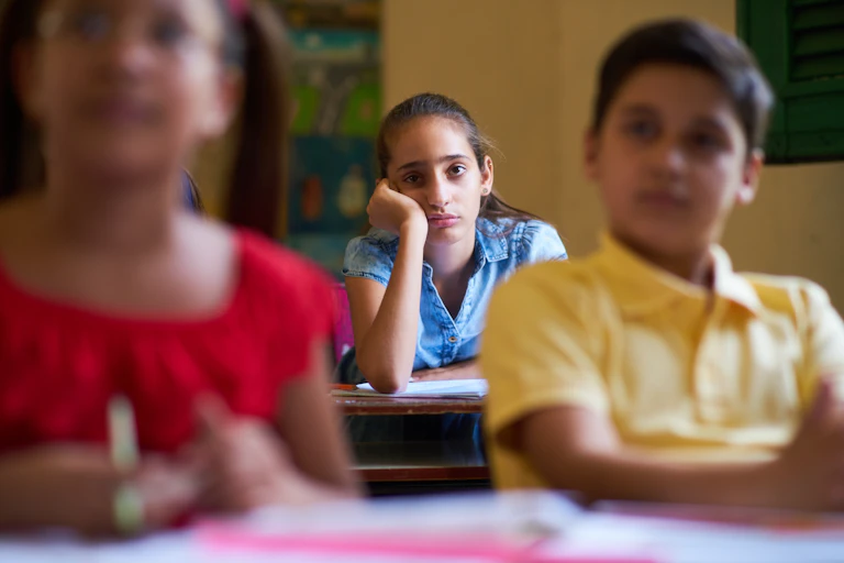 Pensive-looking girl sitting at back of class