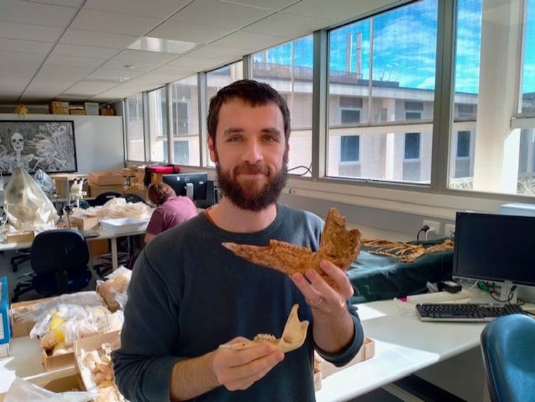 Author Isaac Kerr poses for a photo, holding an Australian giant kangaroo jaw in his left hand