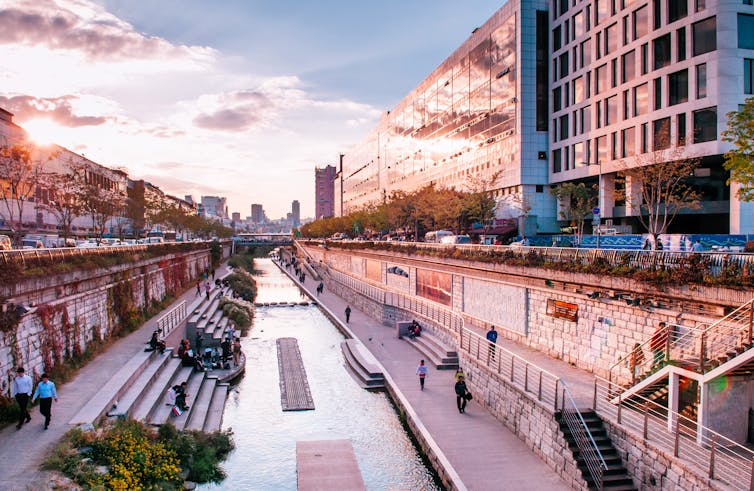 An urban canal pathway seen at sunset.