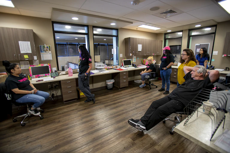 Medical staff at clinic look out the window.