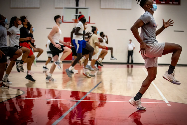 Un groupe de sportifs s'échauffe en salle avant en entraînement de basket