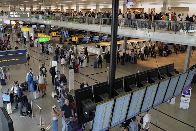 People wait in long lines at an airport