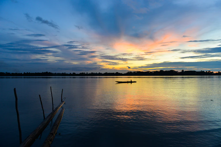 boat silhouette on river at sunset